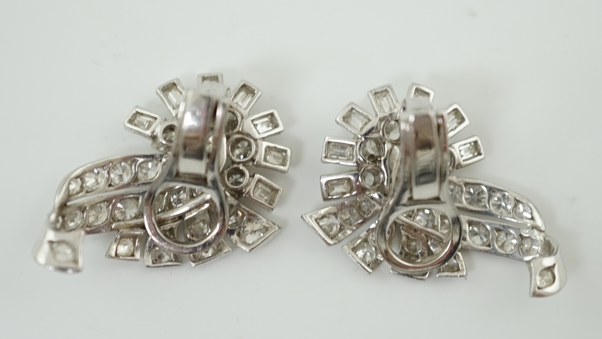 A pair of platinum and diamond cluster scroll ear clips